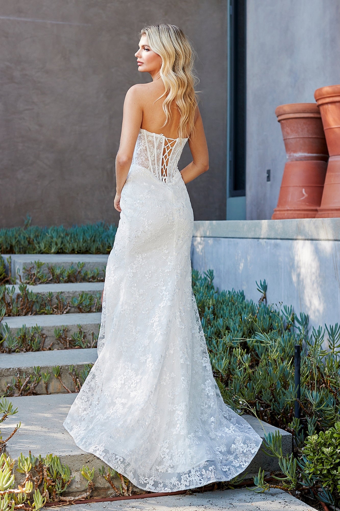 Amelia Couture 7097 strapless white lace floor-length gown with a corset-style lace-up back.